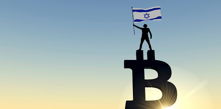 Person waving a israel flag standing on top of a Bitcoin sign