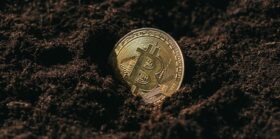 Close up view of golden bitcoin in ground