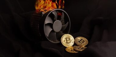 Bitcoin mining device and some golden coins and a flaming computer fan.