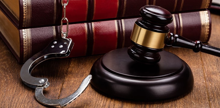 Legal Books On Wooden Table with handcuffs and gavel