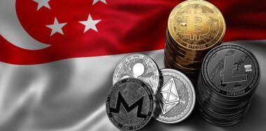 bitcoins in front of the flag of Singapore