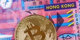 macro image of a golden bitcoin with a 10 Hong Kong dollar bill