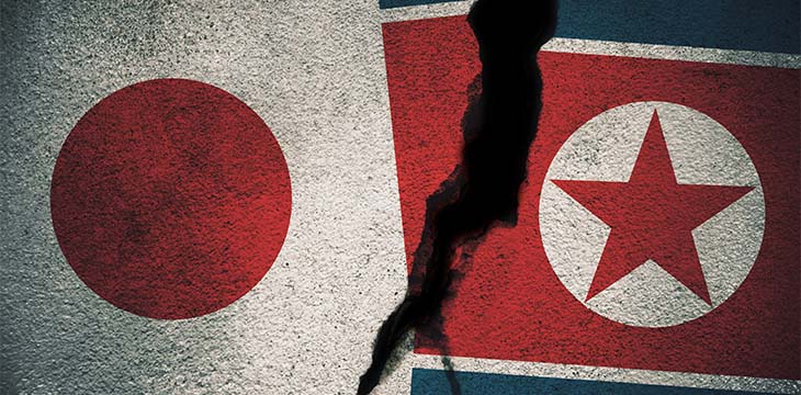 Japan vs North Korea Flags on Cracked Wall — Photo