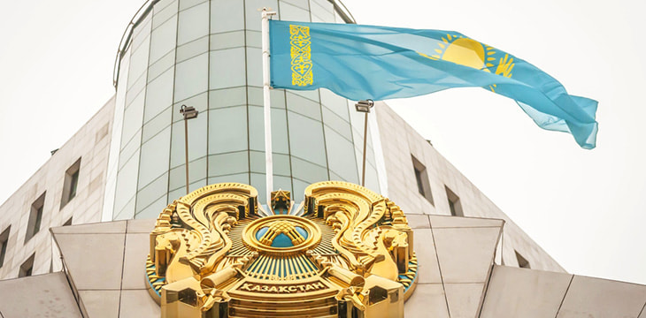 Flag of Kazakhstan and coat of arms over the main entrance to the Kazakhstan Senate building in downtown Astana