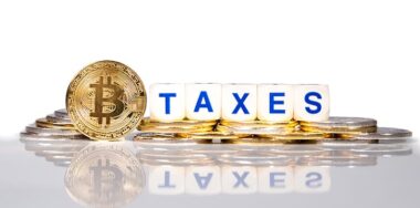 Conceptual cryptocurrency bitcoin with the word Taxes.