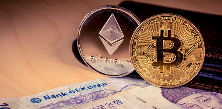 South Korean won currency with the words bank of korea focused and physical bitcoin and ethereum coins. Business concept.