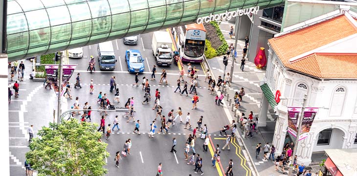 SINGAPORE - FEBRUARY 14, 2015: everyday life of people walking on zebra crossings under Orchard Road Gateway - Crowded city center at rush hour in urban area - Street view from building top — Stock Editorial Photography