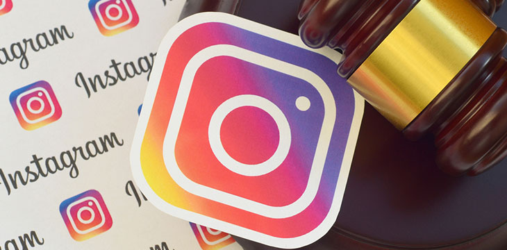 Instagram paper logo lies with wooden judge gavel. Entertainment lawsuit concept