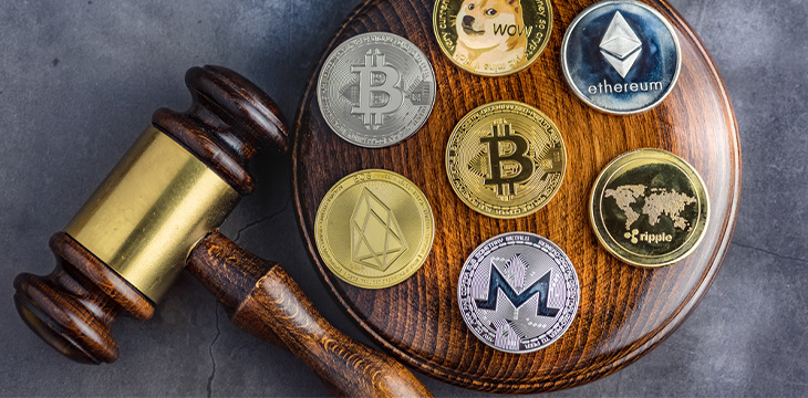 Different cryptocurrencies and gavel over gavel wooden board.Concept image for cryptocurrency