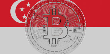 Large transparent Glass Bitcoin in center and on top of the Country Flag of Singapore