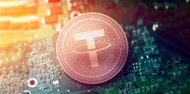 hiny copper TETHER cryptocurrency coin on blurry motherboard