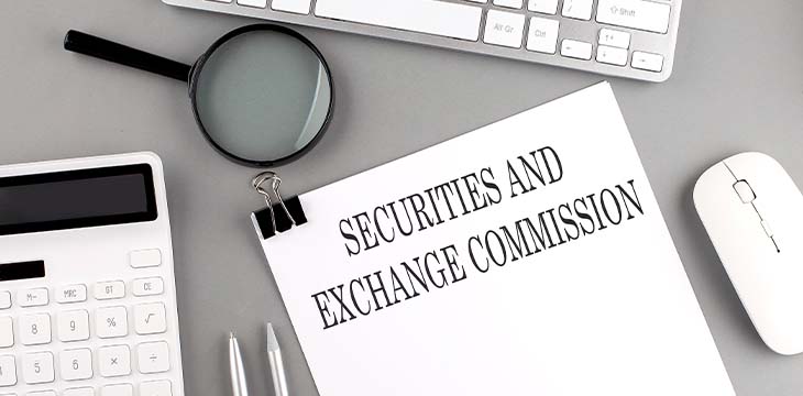 SECURITIES AND EXCHANGE COMMISSION written on paper with office tools and keyboard on grey background — Photo