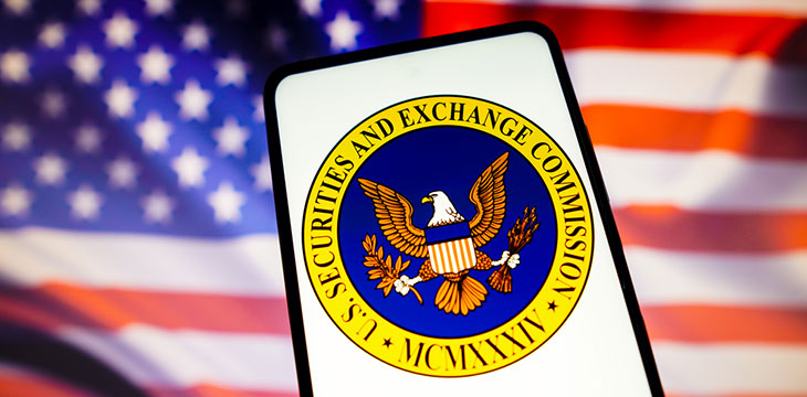 the United States Securities and Exchange Commission (SEC) logo is displayed on a smartphone screen with a United States flag in the background