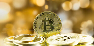 bitcoin on stack of gold coins