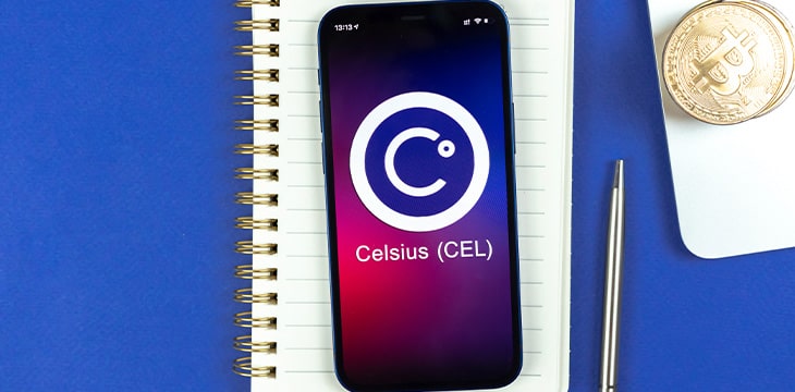 Celsius CEL coin symbol on phone over notebook