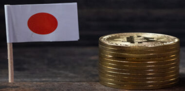 Japanese miniature flag with bitcoins on wooden board
