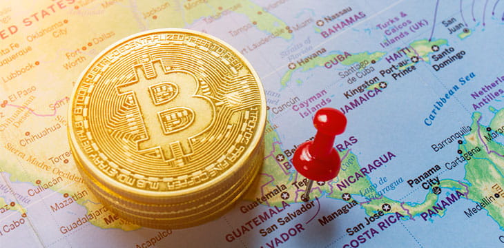 A red pin is pinned on the world map of El Salvador and there is a bitcoin next to it