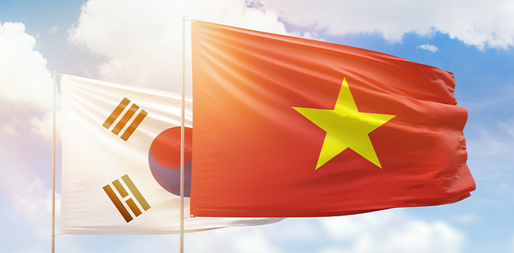 Sunny blue sky and flags of vietnam and south korea