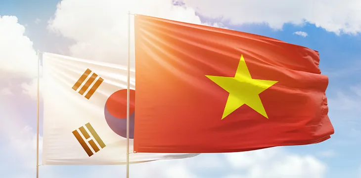 Sunny blue sky and flags of vietnam and south korea