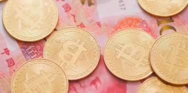 bitcoins in front of chinese banknotes