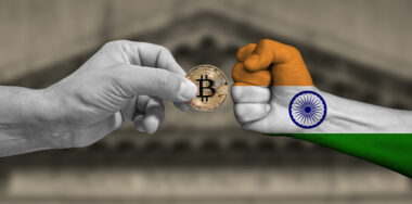Hands fighting with bitcoin and india flag concept