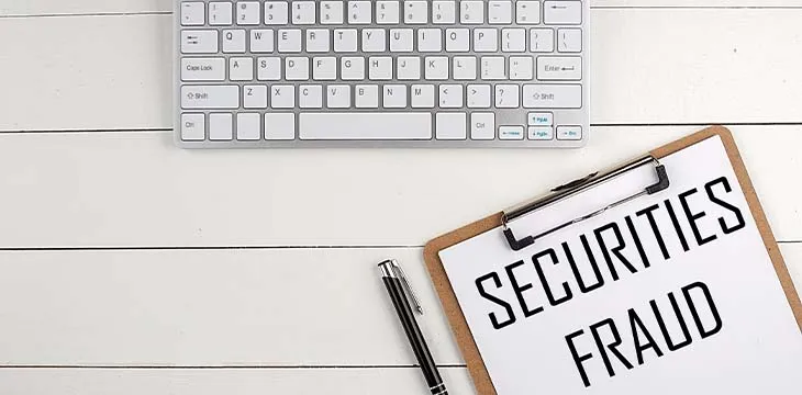 Home office workspace with keyboard, clipboard and pen with text SECURITIES FRAUD on a white wooden background , business concept — Photo