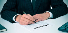 Lawsuit word on document being read and signed by a man in a business corporate suit