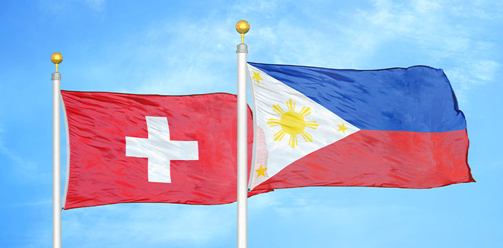 Switzerland and Philippines two flags on flagpoles