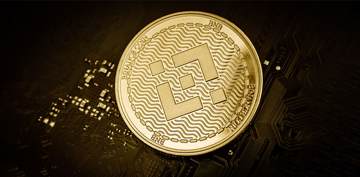 Closeup shot of one golden binance coin over motherboard