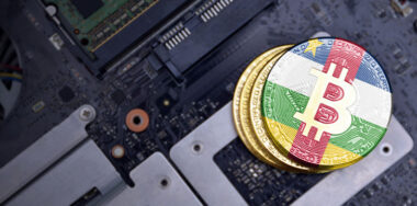 Golden shining bitcoins with flag of central african republic on a computer electronic circuit board. bitcoin mining concept.