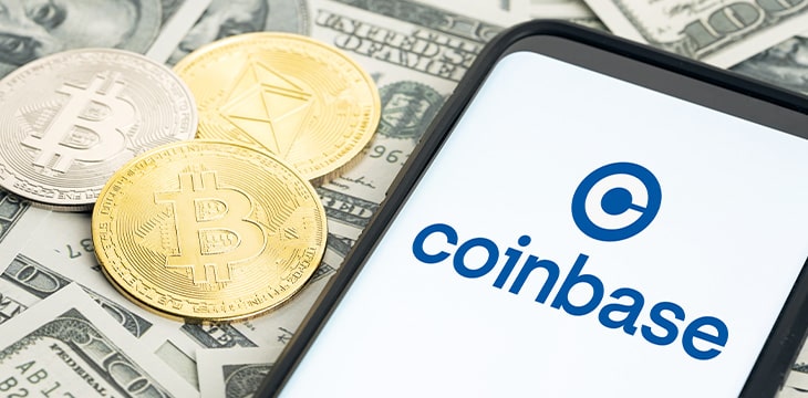 Coinbase logo on Smartphone screen and dollar banknotes and bitcoin and ethereum coins