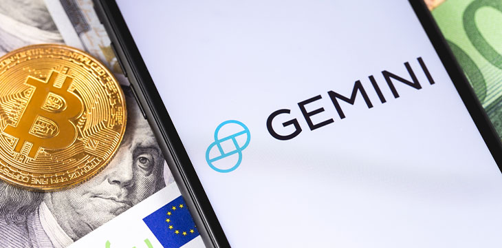 bitcoin and logo of Gemini on phone