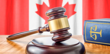 A gavel and a law book in front of Canadian flag