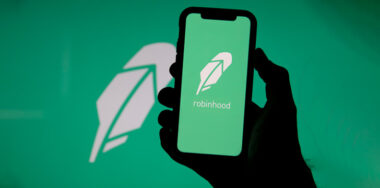 Holding a phone with Robinhood logo on it