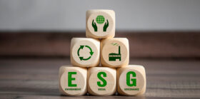 Cubes, dice or blocks with acronym ESG environment social governance on green grass