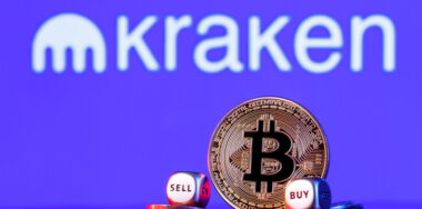 Golden bitcoin with two buy-sell cubes in a pile of coins on the background of the Kraken logo
