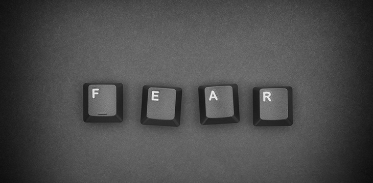 Word Fear written with black computer keyboard keys with dark gradient background