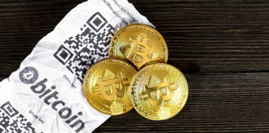 Bitcoin golden coins and paper receipt isolated on a black wood background