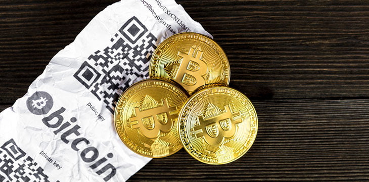 Bitcoin golden coins and paper receipt isolated on a black wood background
