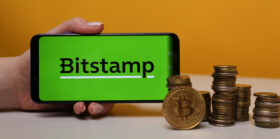 Bitstamp on the phone display with stacks of coins