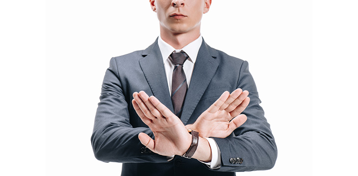 Cropped image of businessman in suit showing rejection sign or hand sign