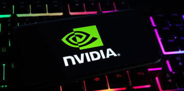 Closeup of mobile phone screen with logo lettering of nvidia corporation on computer keyboard