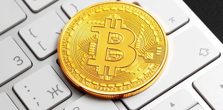 white keyboard with gold bitcoin on top