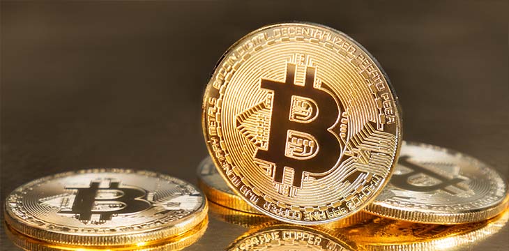 Golden Bitcoins on reflective surface