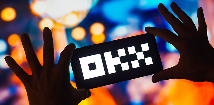 the OKX logo is displayed on a smartphone screen