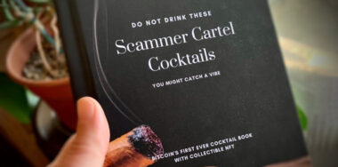 Hand holding a Cigar black book of Scammer Cartel Cocktails