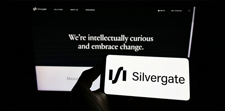 Silvergate logo visible on smartphone screen with website page