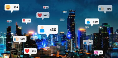 Social media icons fly over city downtown showing reciprocity connection through social network application platform. Concept for online community and social media marketing strategy.