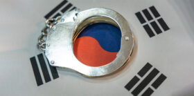 Police handcuffs and South Korea flag