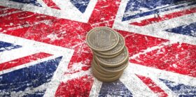 A pile of bitcoin coins on a Britain flag
